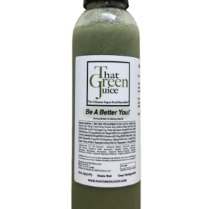 A bottle of green juice on top of a table.
